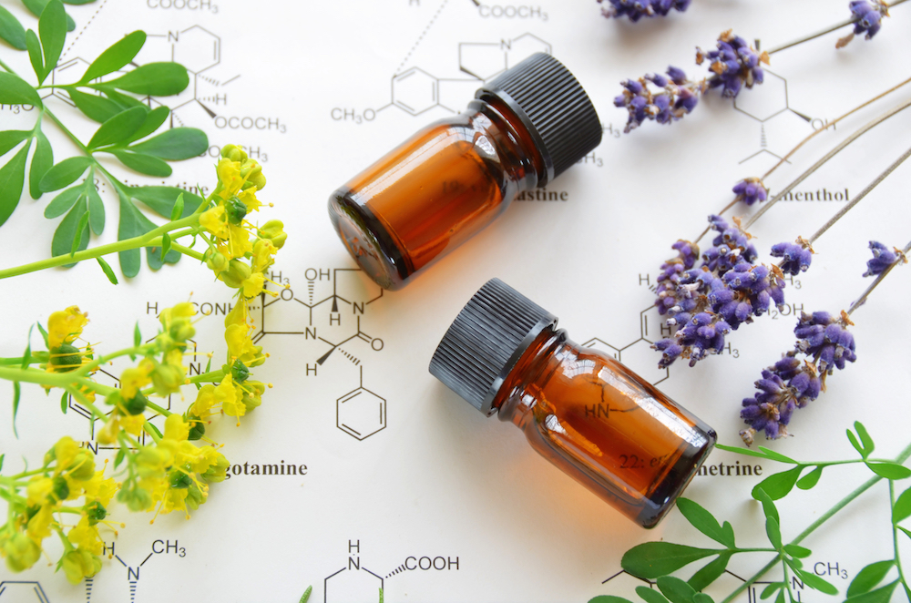 essential oils on science sheet with herbal flowers